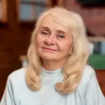 Portrait of smiling elderly woman with blonde hair indoors