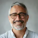 Smiling middle-aged man with glasses and gray beard portrait