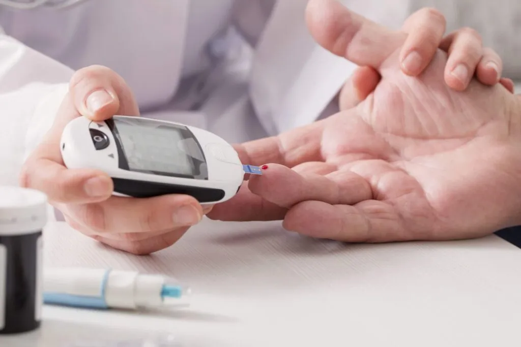 Healthcare professional checking patient blood sugar with glucose monitor