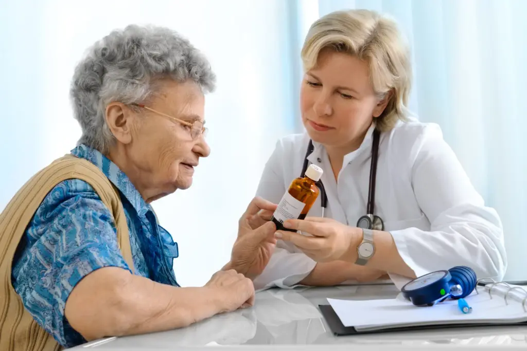 Doctor explaining medication bottle to elderly patient