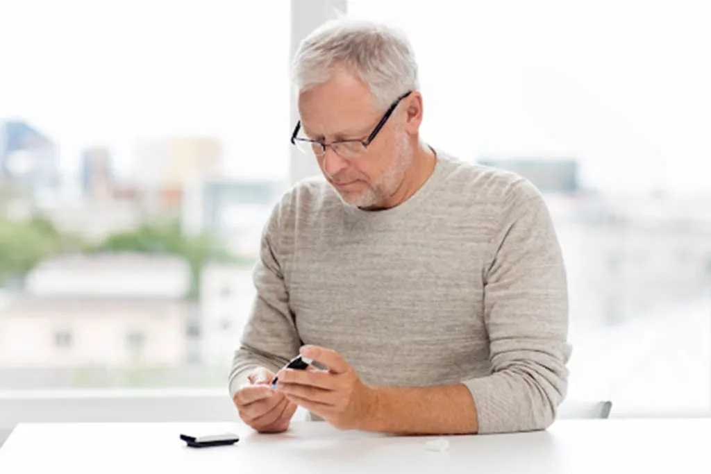 Senior man checking blood glucose levels for diabetes management