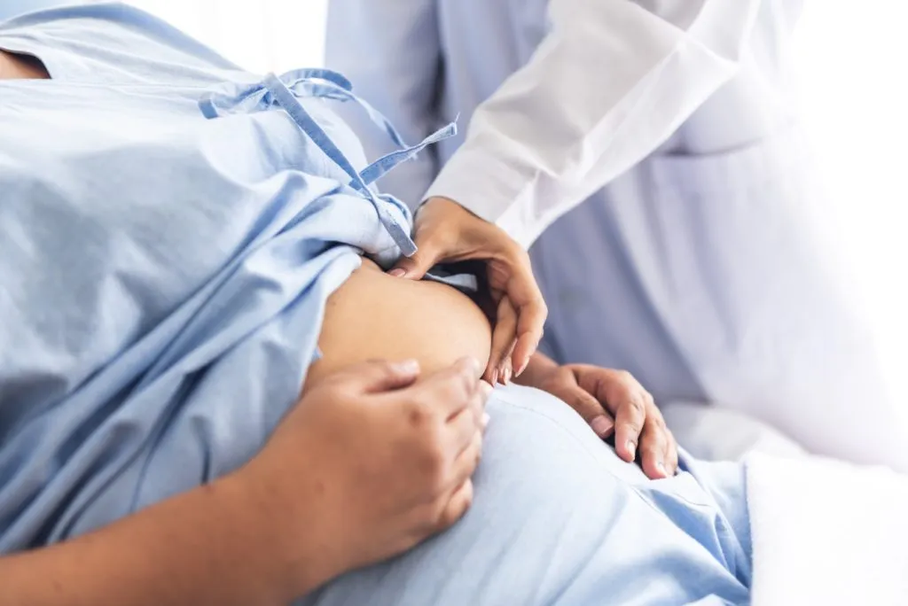 Healthcare professional examining pregnant patient during prenatal checkup