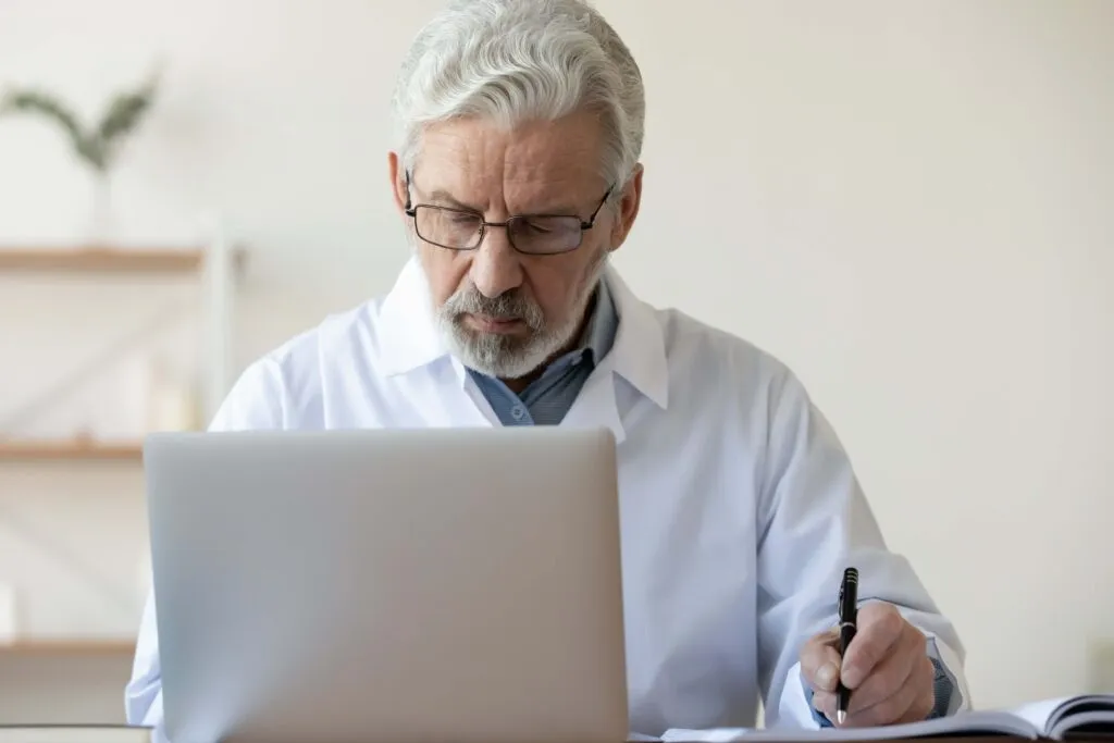 Doctor working on laptop computer in medical office
