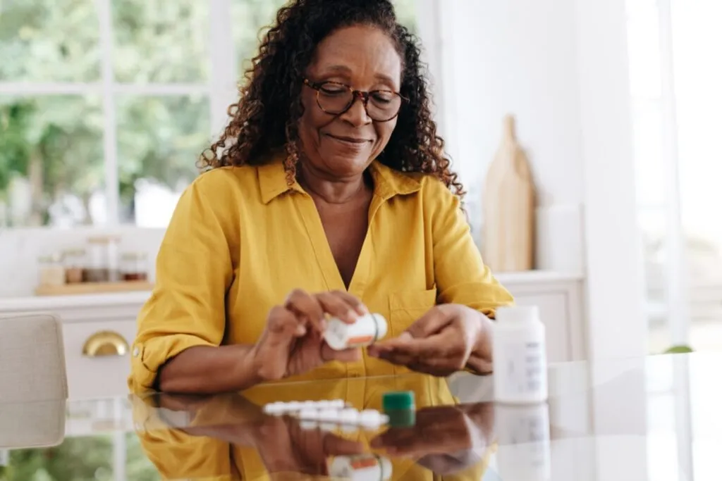 Senior woman organizing daily medication pills at home