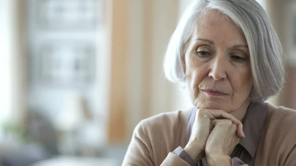 Thoughtful senior woman portrait representing mental health or wellness concerns
