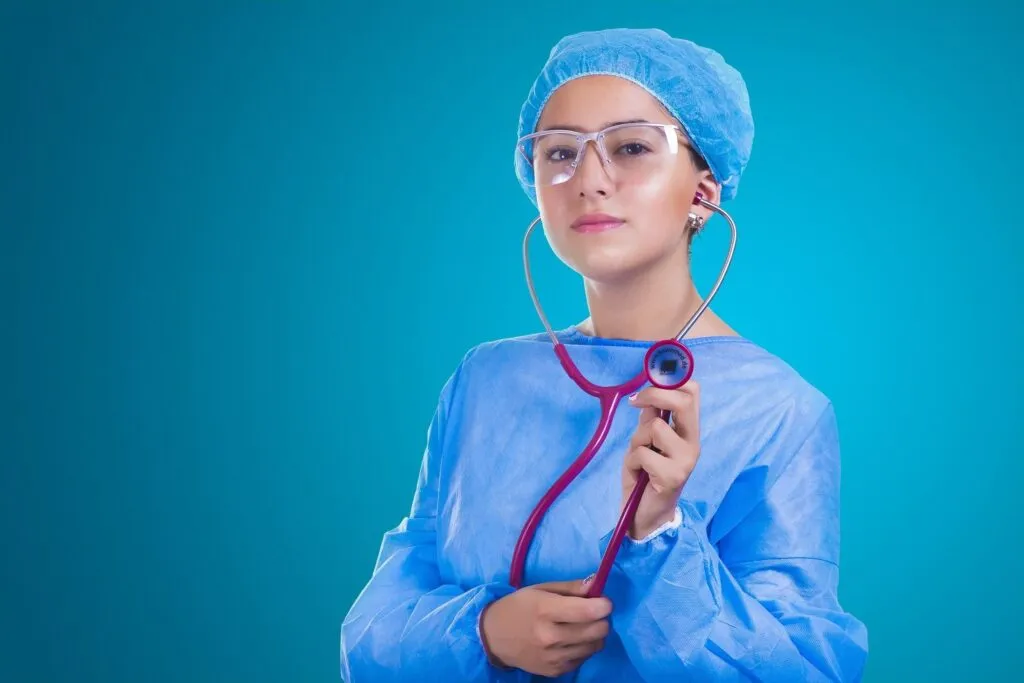Female healthcare professional in protective medical uniform holding stethoscope