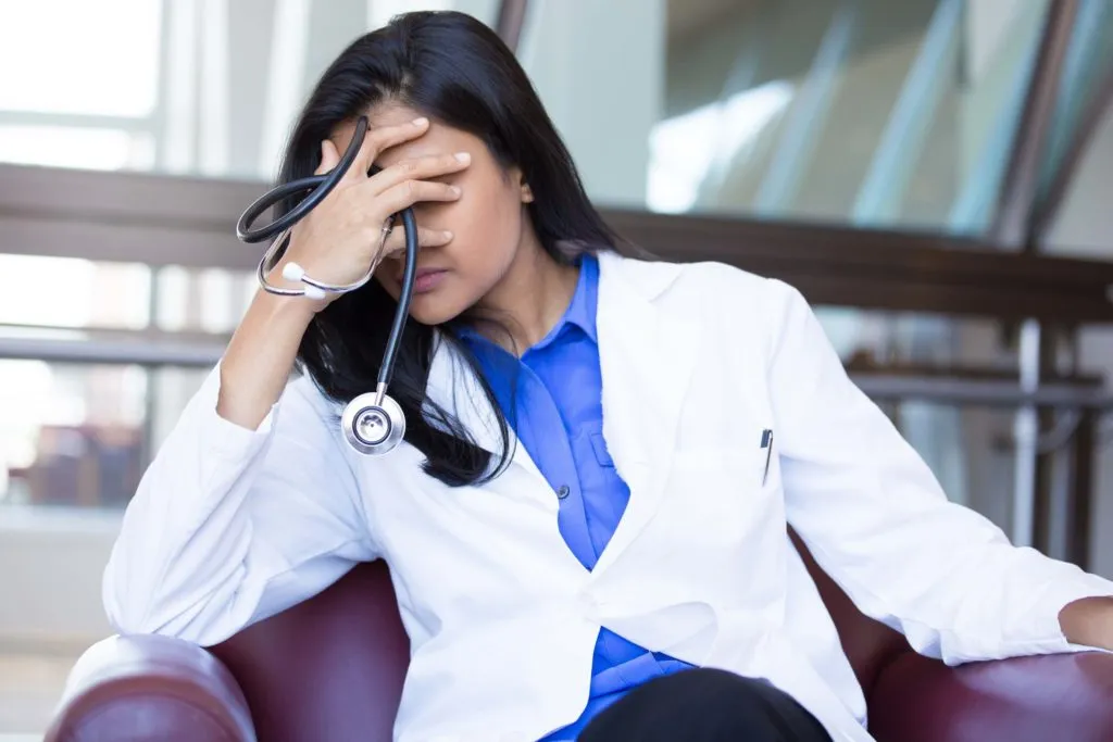 Exhausted female doctor experiencing stress and burnout