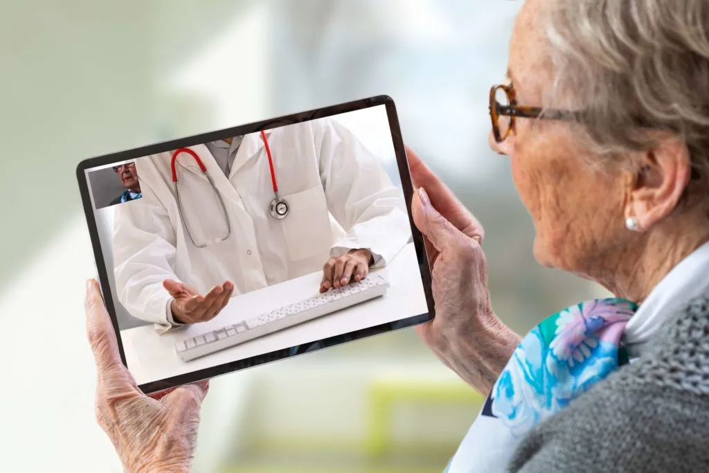 Senior woman attending virtual telehealth consultation on tablet device