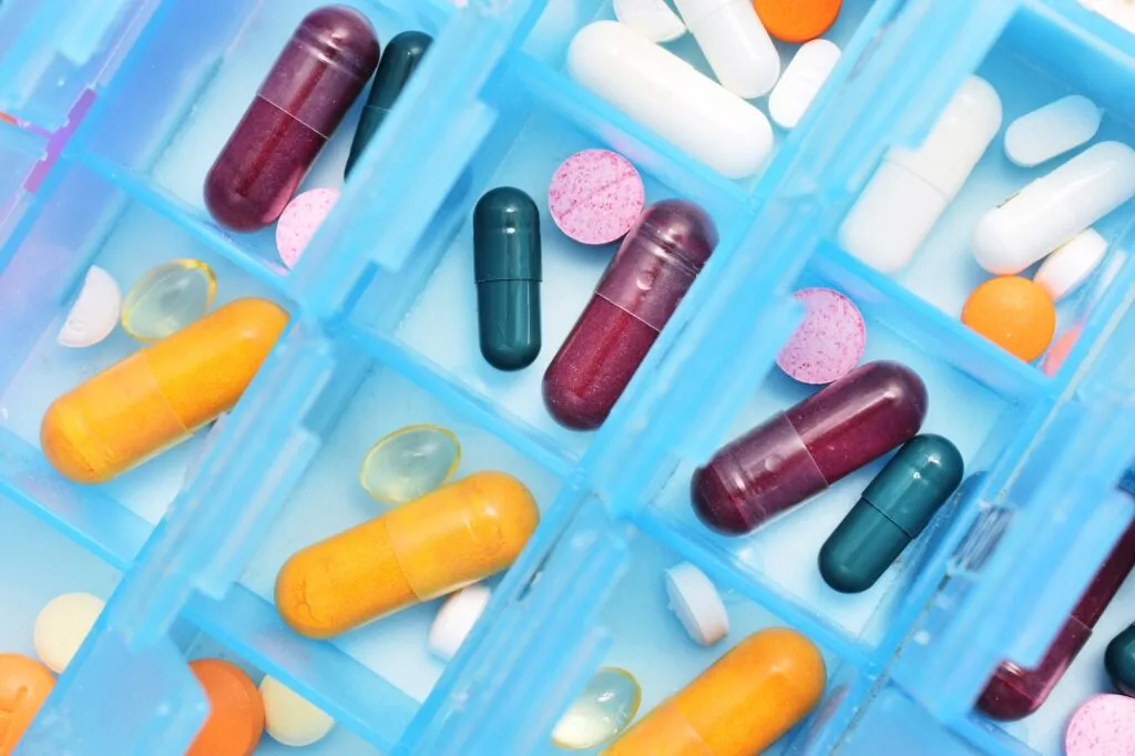 Colorful assorted capsules and pills in weekly medicine organizer
