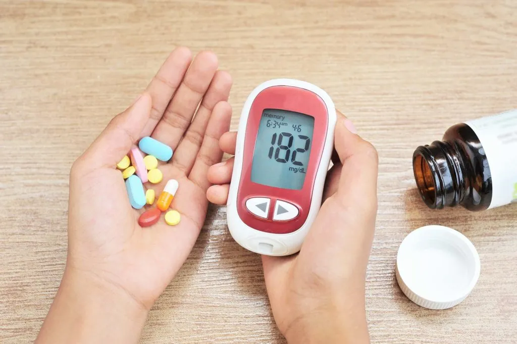 Blood glucose monitor showing high sugar level with diabetes medication