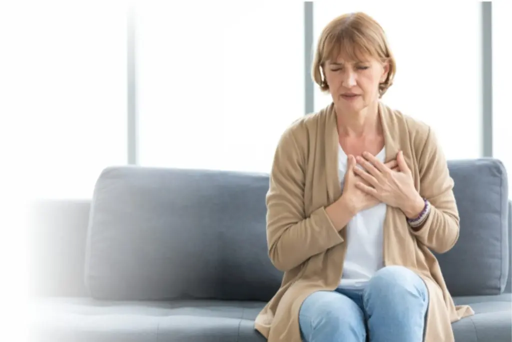 Woman experiencing chest pain and possible heart health symptoms at home