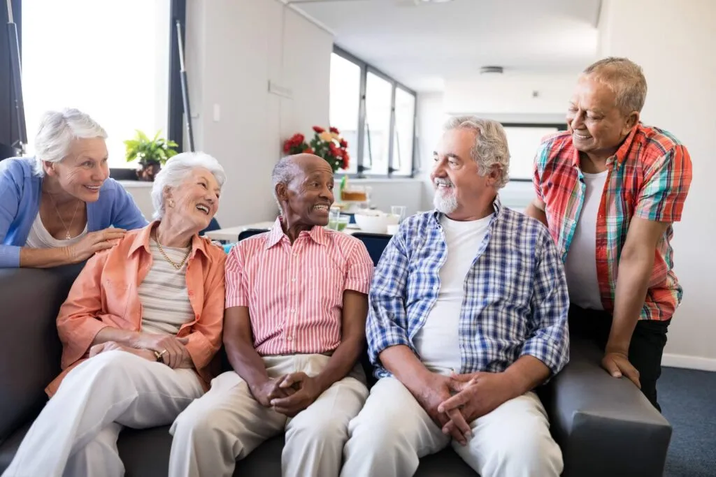 Group of happy senior adults socializing in community care center